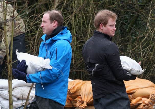Prince William and Prince Harry, up to their knees in water, help shore up flood defences around a school in Datchet, Berkshire. Picture: Getty