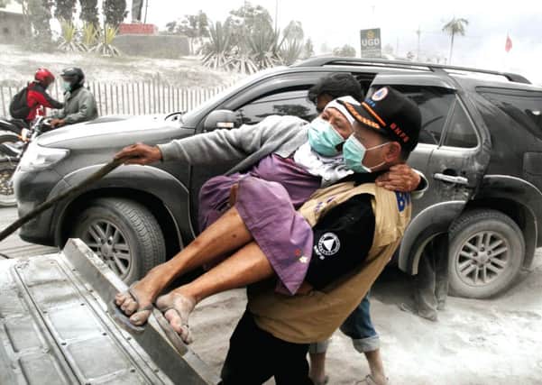 A rescue team evacuates an elderly woman from the worst hit village in Malang, East Java. Picture: Getty
