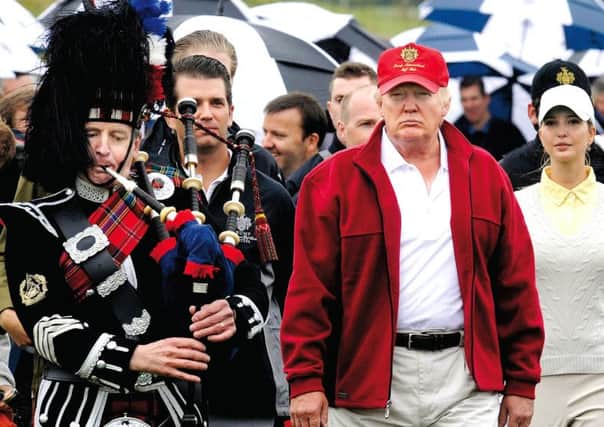 Donald Trump is joined by a piper at the opening of his golf course at Menie. Picture: Getty