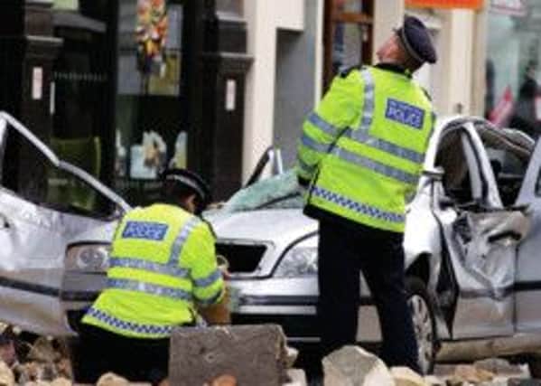 Police investigate the wreck of a car in which a woman was killed by falling masonry. Photograph: Getty Images