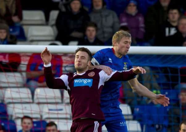 Brad McKay goes up for a high ball with Richie Foran in Inverness. Picture: SNS