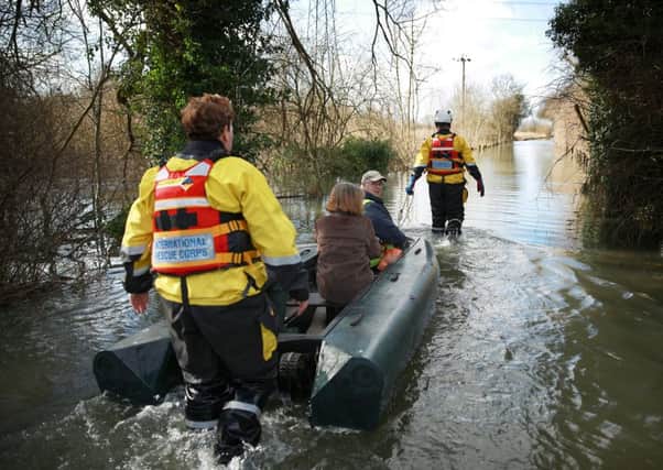 Volunteers help a couple through the floods in Chertsey. Picture: Getty