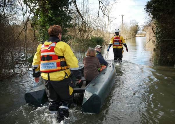 Volunteers help a couple through the floods in Chertsey. Picture: Getty