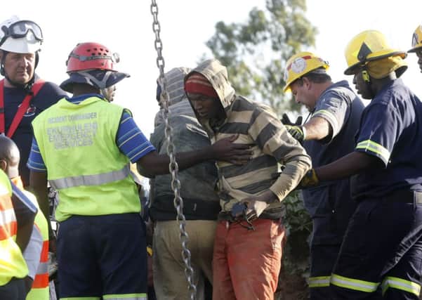 A miner is led away after he was pulled to safety. Picture: Reuters