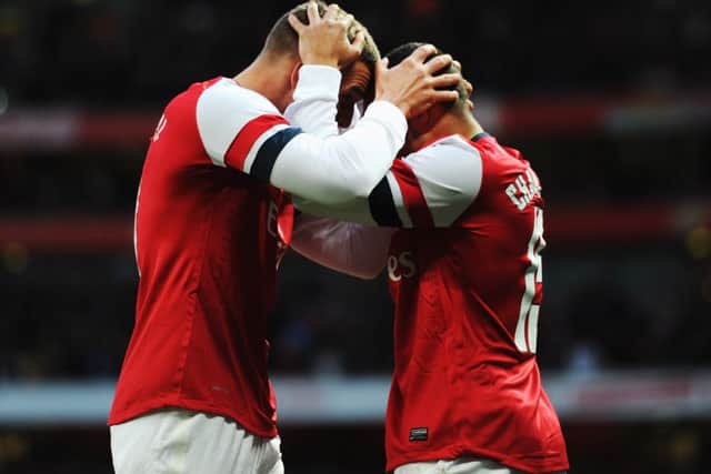 Lukas Podolski, left, celebrates scoring Arsenals second goal with Alex OxladeChamberlain. Picture: Getty