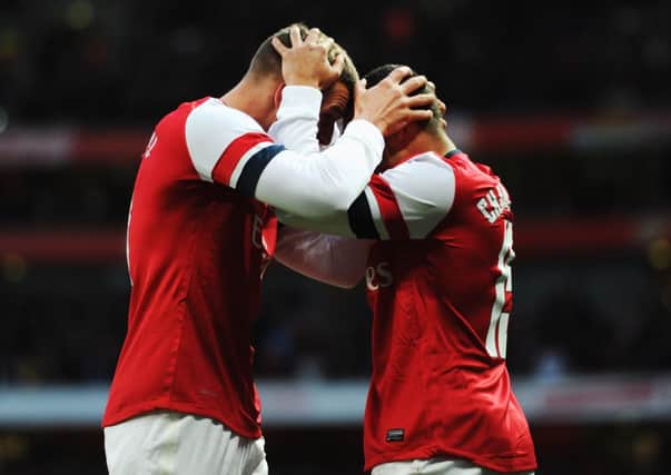 Lukas Podolski, left, celebrates scoring Arsenals second goal with Alex OxladeChamberlain. Picture: Getty