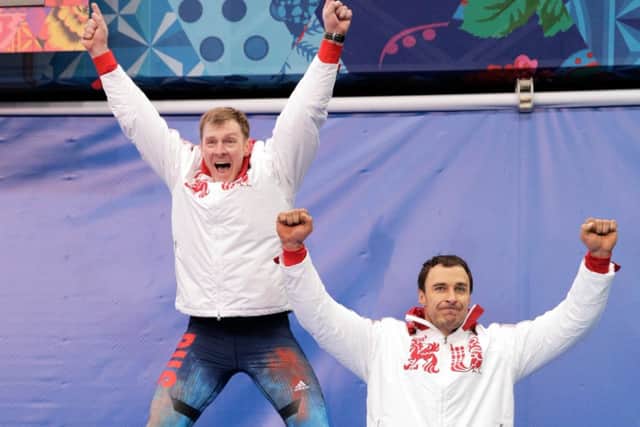 Alexander Zubkov, left, jumps for joy as he celebrates with Alexey Voevoda. Picture: Getty