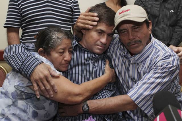 Jose Salvador Alvarenga with his father Ricardo Orellana, right, and mother Maria Julia. Picture: AP