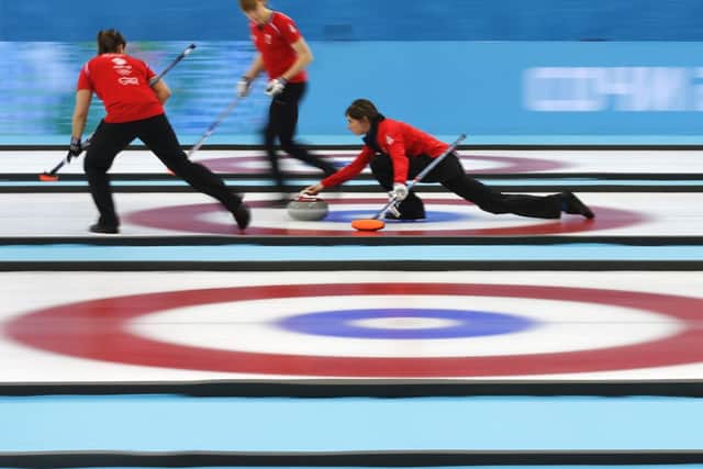 Eve Muirhead, right, delivers the rock as her teammates Claire Hamilton, center, and Vicki Adams, left, prepare to sweep the ice. Picture: AP