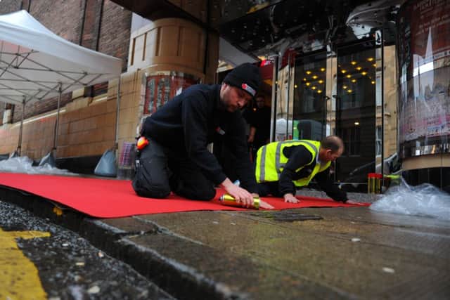 Workmen laying the red carpet outside the GFT yesterday. Picture: Robert Perry