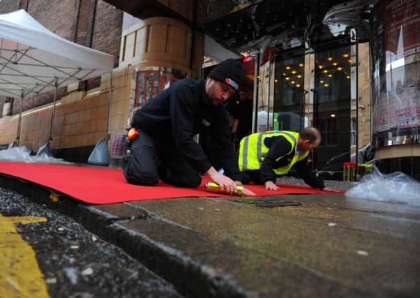 Workmen laying the red carpet outside the GFT yesterday. Picture: Robert Perry