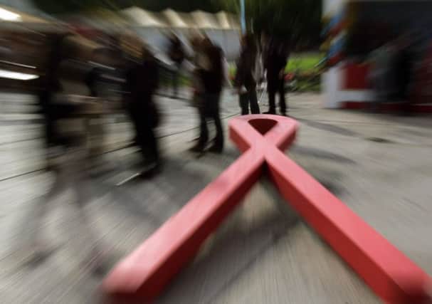 People get information about AIDS near a giant red ribbon in the centre of Athens. Picture: Getty