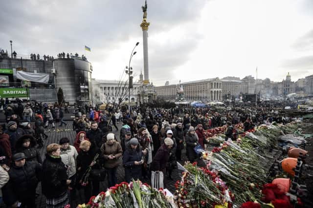 People lay flowers and mourn antigovernment protesters killed in Kiev. Picture: Getty Images