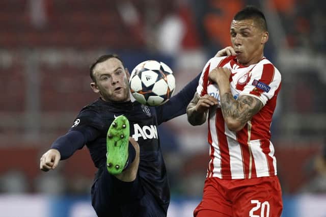 Manchester Uniteds Wayne Rooney challenges Jose Holebas. Picture: Yorgos Karahalis/Reuters