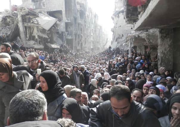 Residents wait to receive food aid distributed by the U.N. Relief and Works Agency (UNRWA). Picture: Reuters