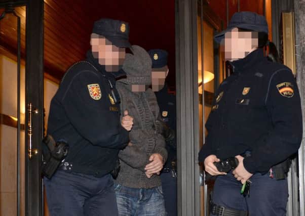 Officers remove a suspect after raiding a property in Spain. Picture: PA