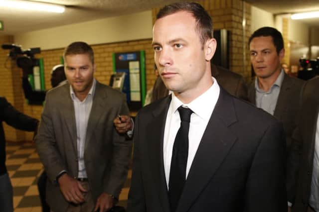 Oscar Pistorius (C) arrives at court for the opening day of his murder trial. Picture: AFP
