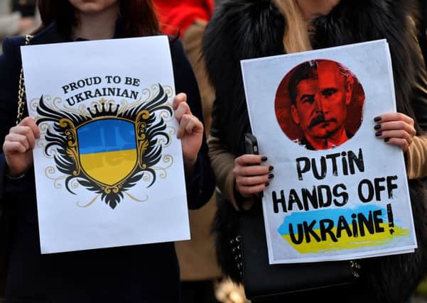 Protesters hold placards during a demonstration against Russia's involvement in the crisis in Ukraine, in London's Parliament Square yesterday. Picture: Getty