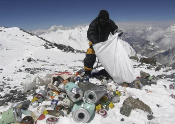 A sherpa collects some of the rubbish left behind by climbers on the slopes of Mound Everest. Picture: Getty
