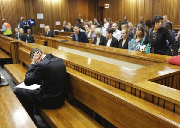 Athlete Oscar Pistorius covers his ears as he sits in court yesterday during the murder trial. Picture: Reuters