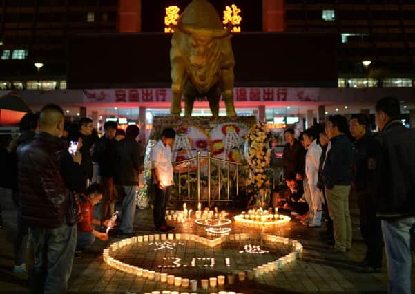 Chinese mourners lighting candles at the scene of the terror attack at the main train station in Kunming, in southwest China's Yunnan Province. Picture: Getty