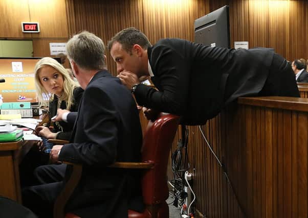 Oscar Pistorius leans over to speak to his counsel on the third day of his trial. Picture:AP