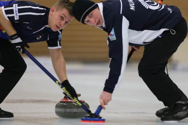 Kyle Waddell, left, and Thomas Muirhead guide one of Kyle Smiths stones  Picture:  Richard Gray