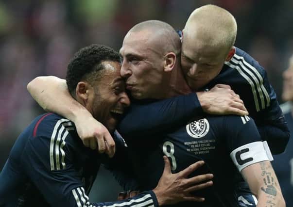 Scotland goalscorer Scott Brown is congratulated by Ikechi Anya, left, and Steven Naismith. Picture: Reuters
