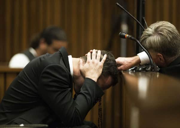 Pistorius, holding rosary beads, covered his head in court as he listened to witness accounts of his former partners death. Picture: Getty