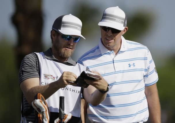 Hunter Mahan, right, listens to his caddie John Wood. Picture: AP