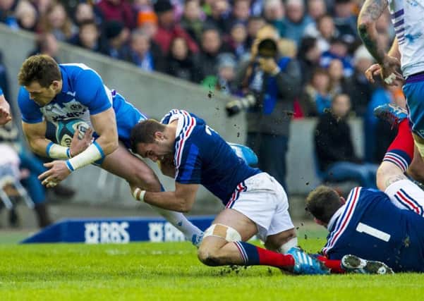 Scotland's Sean Lamont (left) is tackled by Alexandre Lapandry. Picture: SNS