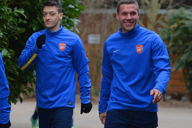 Arsenal duo Mesut Ozil and Lukas Podolski get ready to limber up for tonights clash. Picture: Getty