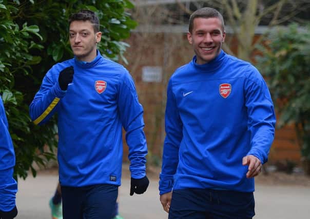 Arsenal duo Mesut Ozil and Lukas Podolski get ready to limber up for tonights clash. Picture: Getty