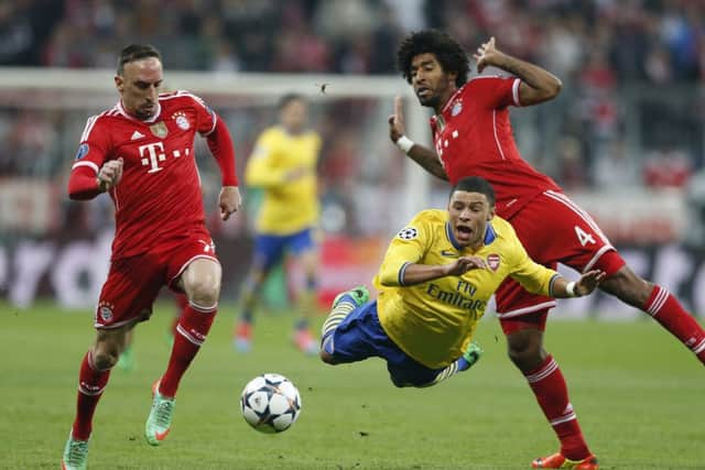 Arsenal's Alex Oxlade-Chamberlain, center, is tackled by Bayern's Franck Ribery, left, and  Dante. Picture: AP