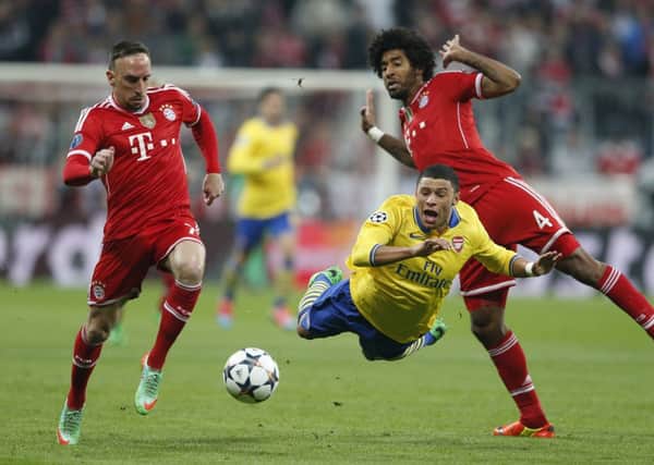 Arsenal's Alex Oxlade-Chamberlain, center, is tackled by Bayern's Franck Ribery, left, and  Dante. Picture: AP