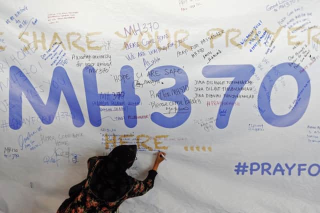 A woman writes a message of support on a banner at Kuala Lumpur International Airport yesterday. Picture: Reuters