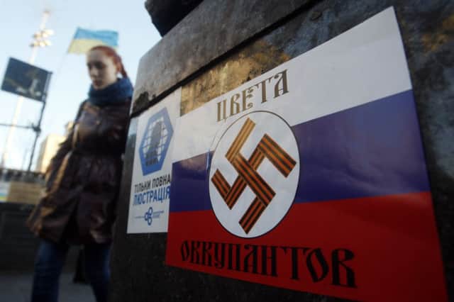 A poster with a swastika on a Russian flag reads The colours of the occupiers in Kiev. Picture: Getty