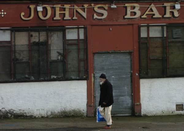 A man walks past a pub in the Calton area of Glasgow. More community engagement is needed to tackle longstanding health inequalities in Scotland, a report says. Picture: Ian Rutherford