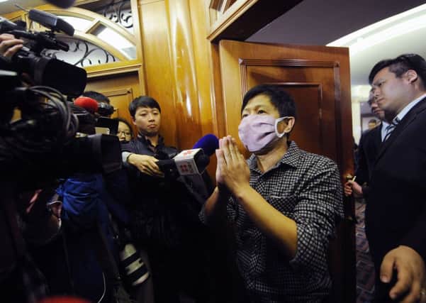 A man wearing a mask, who claimed to be a relative of a passenger from the missing Malaysia Airlines flight MH370, speaks to the media. Picture: Getty