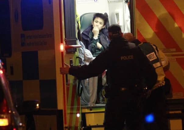 A member of the public is treated at the scene of the attack on the Falls Road. Picture: AP