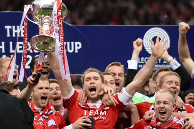 Russell Anderson lifts the Scottish League Cup after Aberdeen won a penalty shoot-out 4-2 against Inverness. Picture: SNS