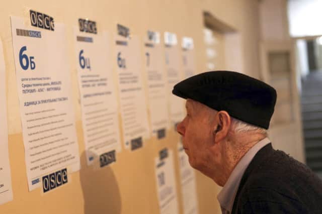 A man studies the instructions before casting his vote in Mitrovica. Picture: Reuters