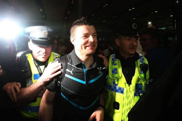 A fulfilled Brian ODriscoll is escorted through crowds of well-wishers at Dublin Airport. Picture: PA