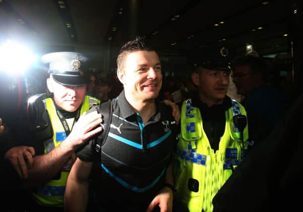 A fulfilled Brian ODriscoll is escorted through crowds of well-wishers at Dublin Airport. Picture: PA