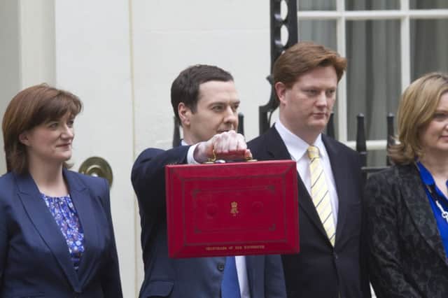 Chancellor George Osborne holds his budget box next to members of the Treasury. Picture: PA