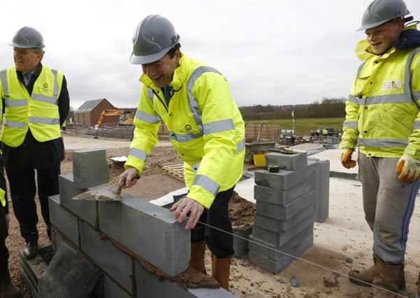 Chancellor George Osborne lays a block during a visit to a Barratt Homes building site in Nuneaton. Picture: PA