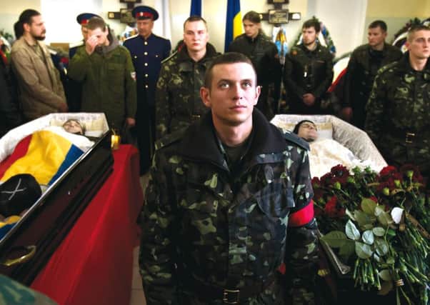 A Ukrainian soldier stands between the coffins of soldier Sergey Kokurin, 35, right, and militiaman Ruslan Kazakov, 34, during their joint funeral in Simferopol. Photograph: AP