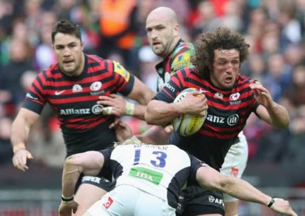 Jacques Burger of Saracens is tackled by Quins Matt Hopper during yesterdays record-breaking match at Wembley. Photograph: Getty