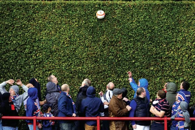 Follow foliage: Rangers fans bask in the shadow of the famous hedge, which does a good job of keeping the matchball in the ground, on their previous visit. Photograph: SNS