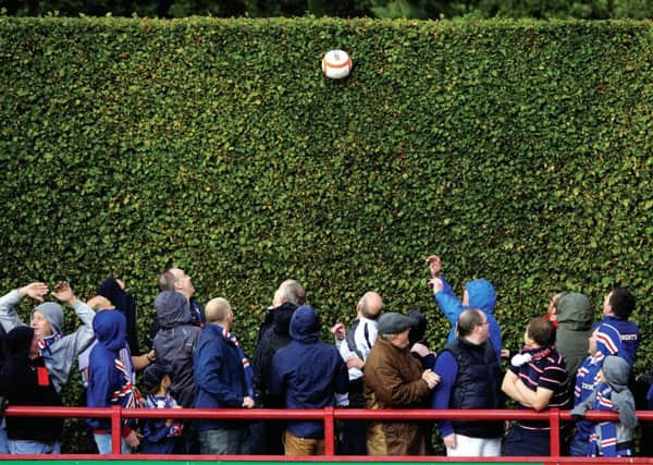 Follow foliage: Rangers fans bask in the shadow of the famous hedge, which does a good job of keeping the matchball in the ground, on their previous visit. Photograph: SNS